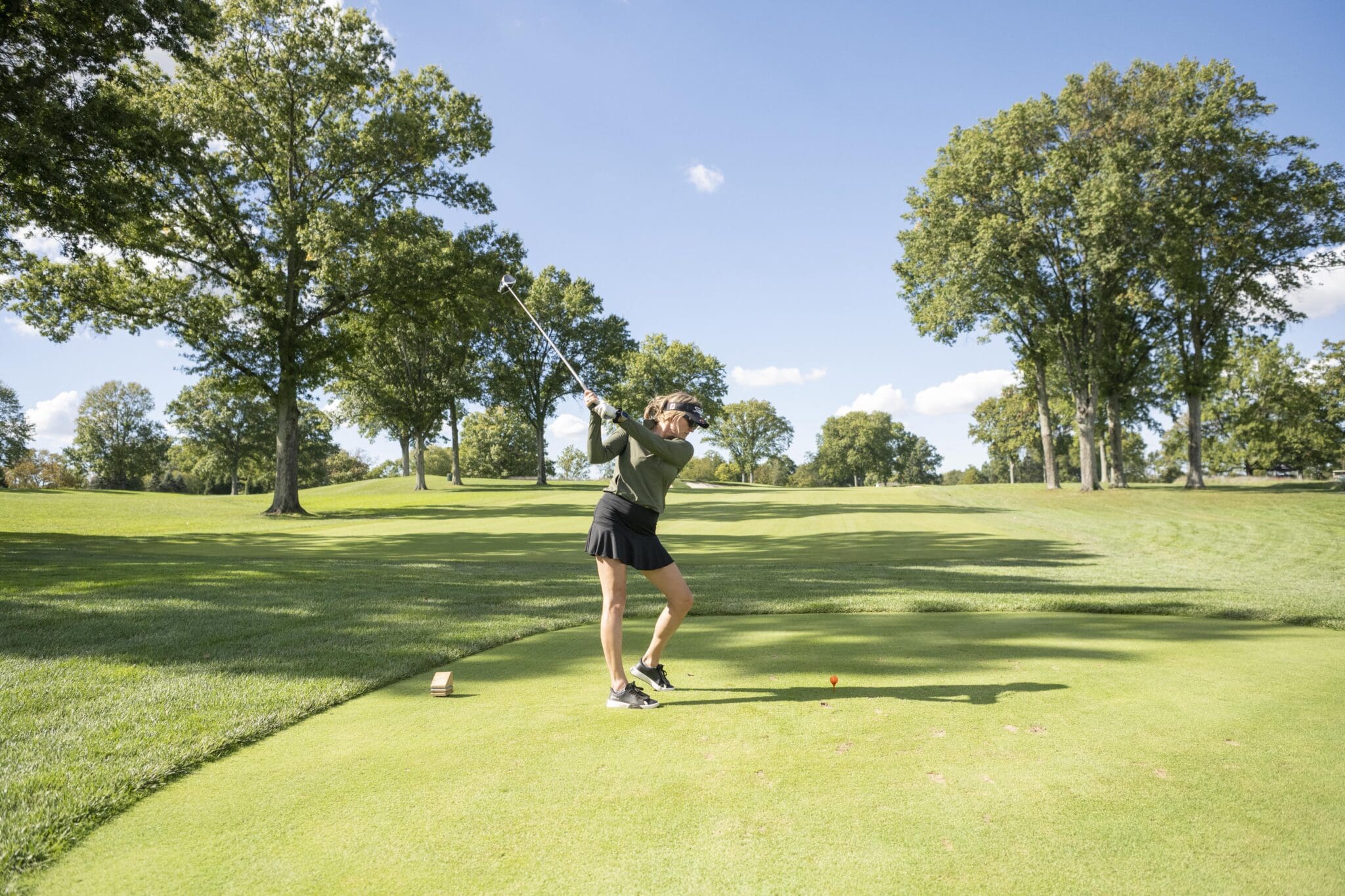 A golfer teeing off on the fairway