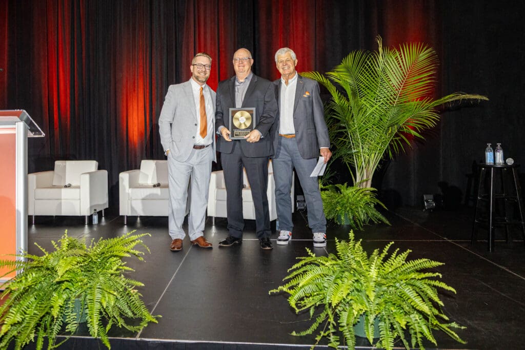 Volunteer Mark Meinerding receives the Thrive Award at Ken and Friends, joined by KAA CEO Patrick Ober and Founder Ken Anderson